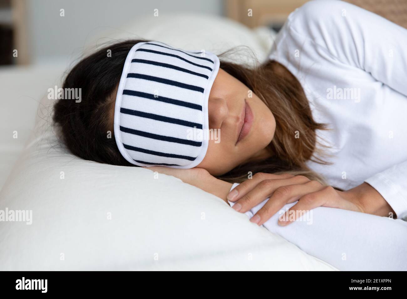 Primo piano donna calma che indossa la maschera che riposa nel letto Foto Stock