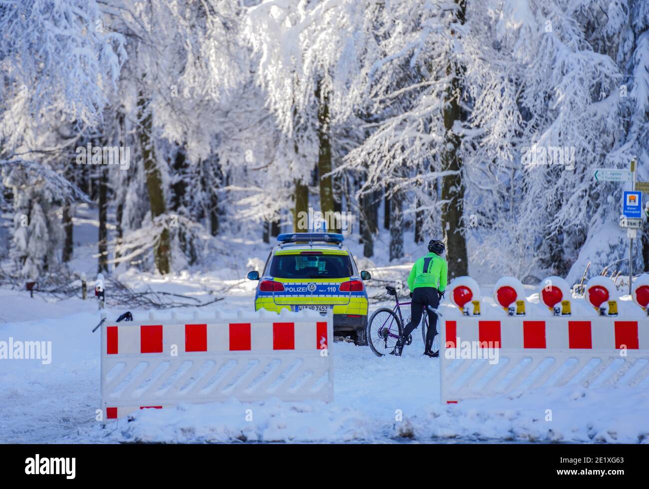 Schmitten, Germania. 10 gennaio 2021. Un ciclista spinge la sua moto attraverso la chiusa German Limes Road. La zona di Feldberg nel Taunus è chiusa a causa della rottura della neve e per evitare un assalto di escursionisti invernali. La vetta può essere raggiunta solo senza trasporto motorizzato. Credit: Andreas Arnold/dpa/Alamy Live News Foto Stock