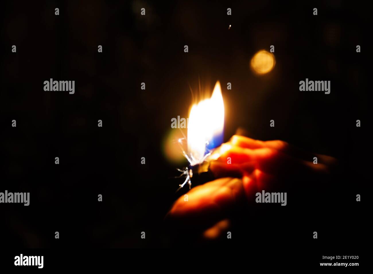 Una donna illumina una luce in una stanza buia. Un effetto fotografico concettuale derivante da una velocità dell'otturatore ridotta. Foto Stock
