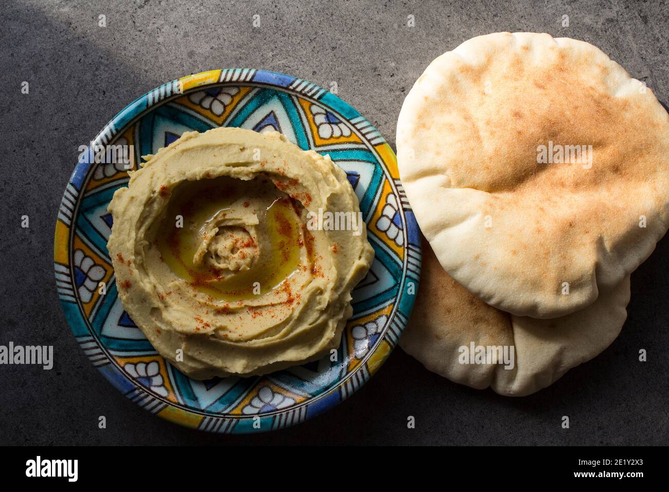 Gustoso hummus su piatto colorato. Foto dall'alto del cibo tradizionale di Israele. Concetto di dieta equilibrata. Hummus israeliano classico. Foto Stock
