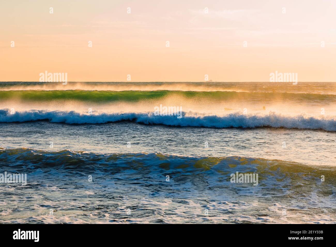 Onde oceaniche al caldo tramonto o all'alba. Onde e vento con la luce della sera Foto Stock