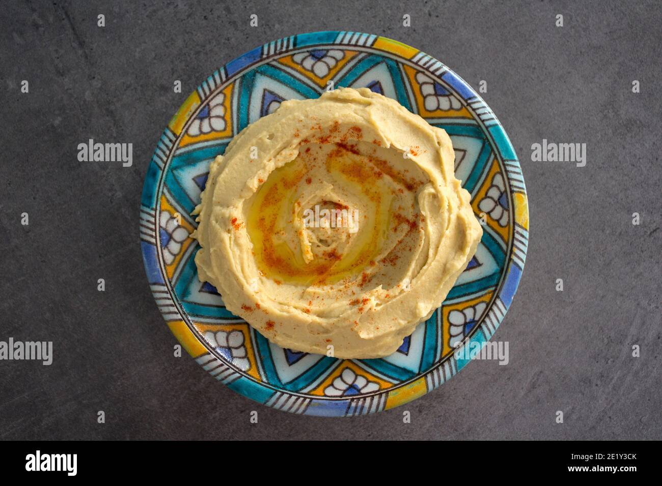 Gustoso hummus su piatto colorato. Foto dall'alto del cibo tradizionale di Israele. Concetto di dieta equilibrata. Hummus israeliano classico. Foto Stock