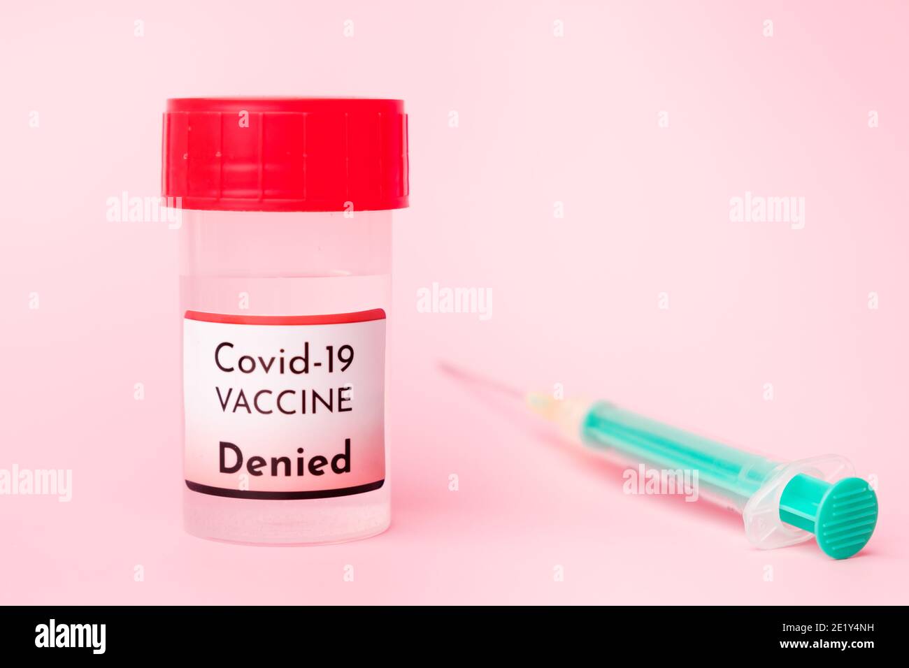 Vaccino Covid-19 negato nel flacone e siringa monouso per iniezione su fondo rosa. Prevenzione del coronavirus, Sars-Cov-2. Foto Stock