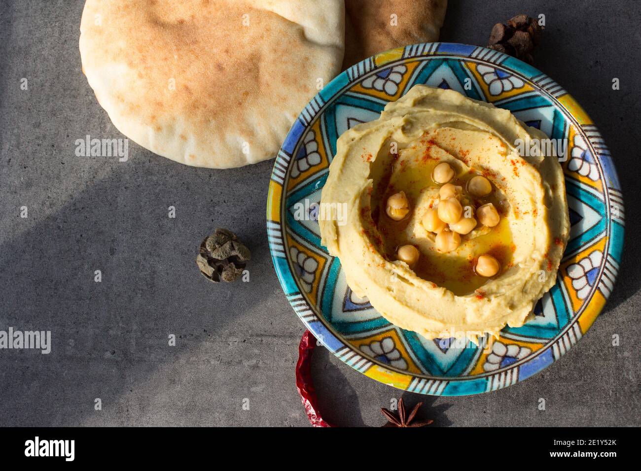 Primo piano foto di un hummus fresco fatto in casa su una colorata piastra in ceramica. Foto pasto bilanciato. Concetto di alimentazione sana. Cibo autentico del Medio Oriente. Foto Stock