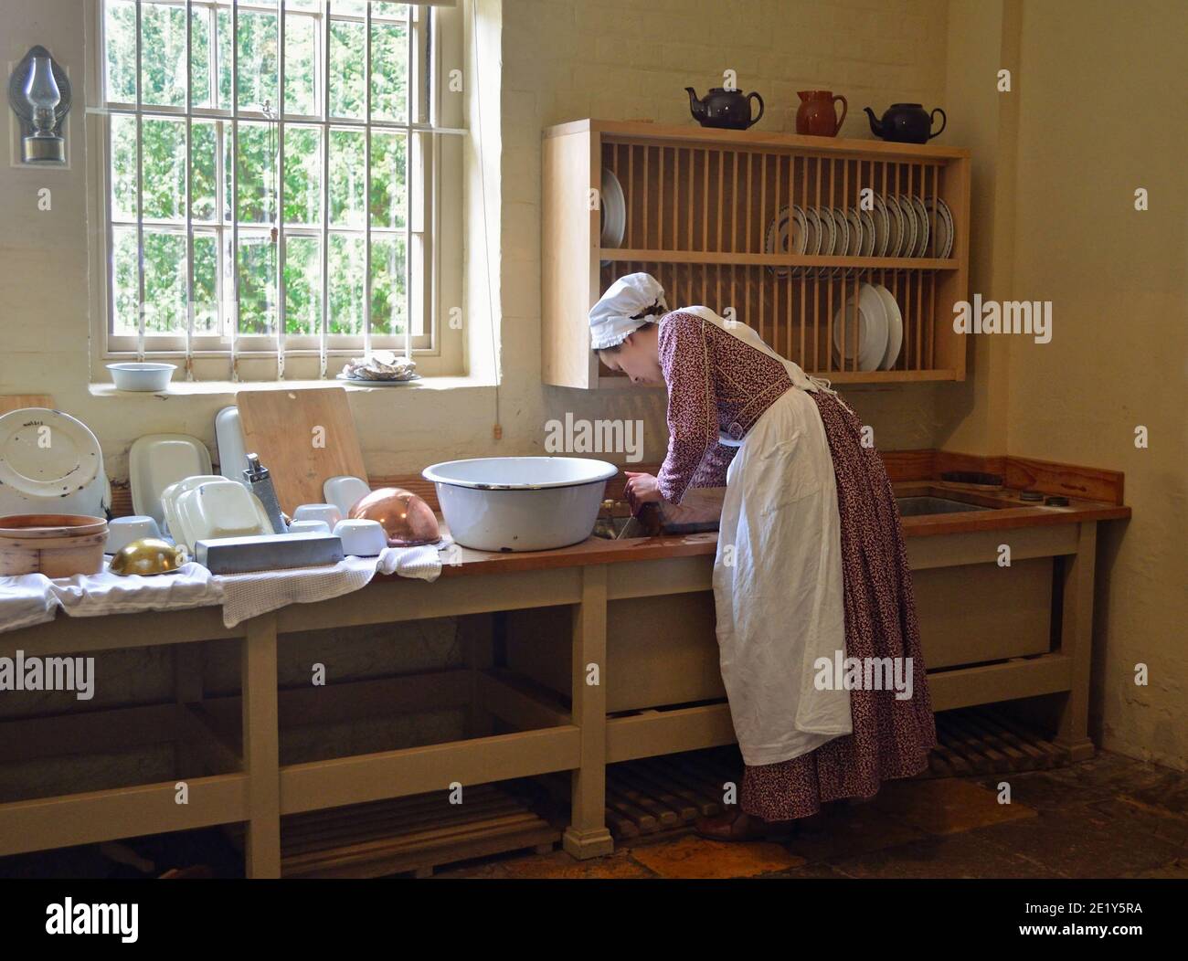 Cucina vittoriana pulizia piatti nel lavandino. Foto Stock