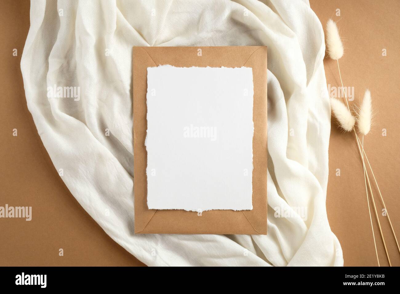 Elegante mockup di carte di invito per matrimoni con sciarpa femminile e fiori secchi su sfondo marrone. Disposizione piatta, vista dall'alto. Foto Stock