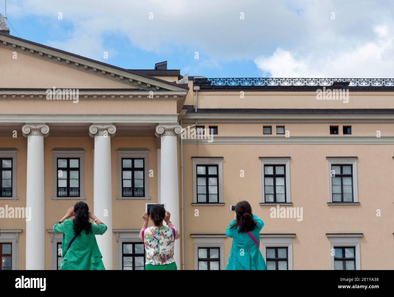 Tre donne asiatiche fotografano lo stesso motivo. Vista da dietro. Foto del Castello reale di Oslo. Foto Stock