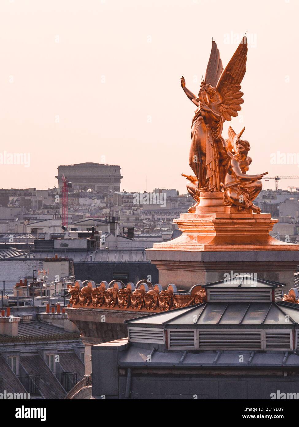 Foto scattata dai tetti di Parigi. Statua di poesia appartenente al Palazzo Garnier in primo piano e l'arco trionfale sullo sfondo. Foto Stock