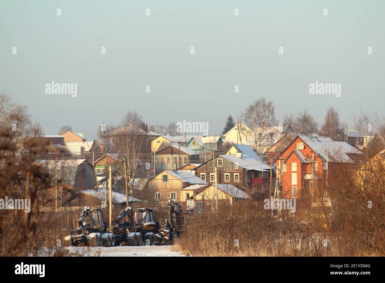 Eleganti case in legno multicolore in un paesaggio rurale naturale, giorno d'inverno limpido. Umore invernale festivo. Foto a stock con spazio vuoto per testo e design. Foto Stock