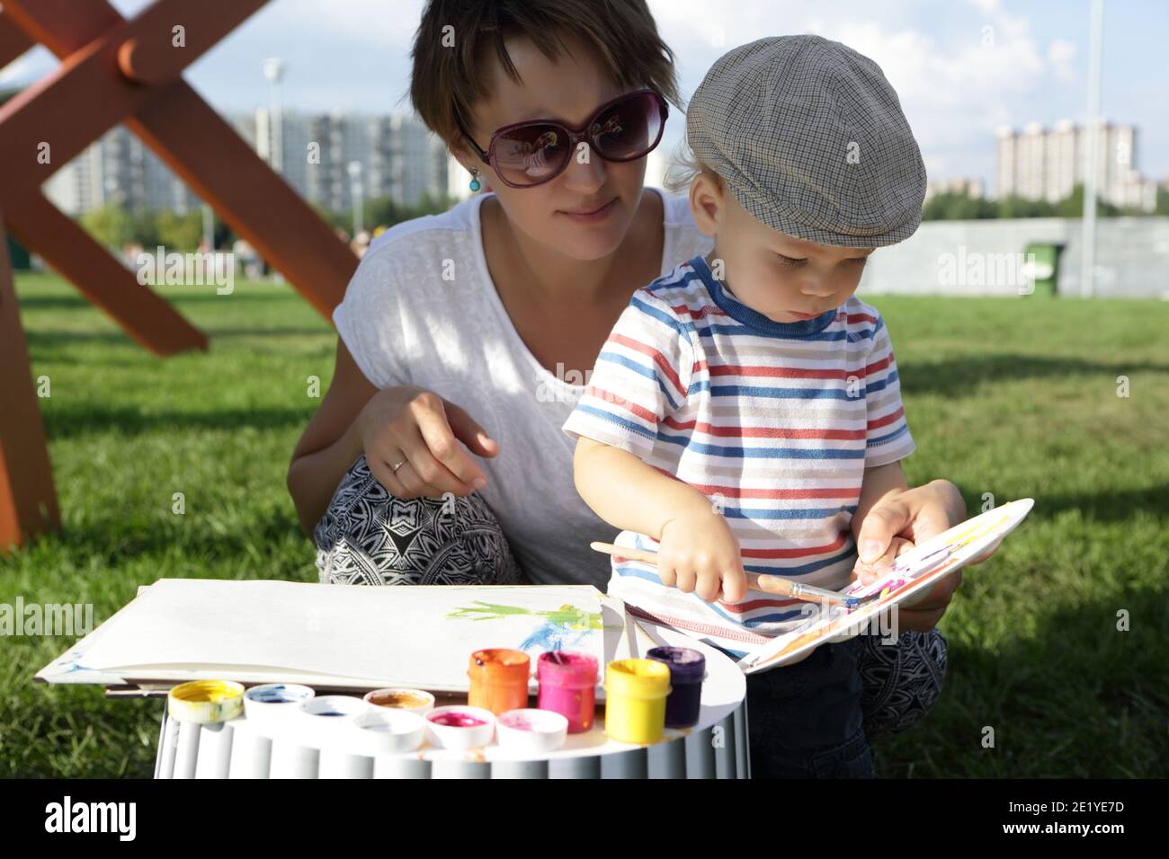 Madre con suo figlio disegno gouache nel parco Foto Stock