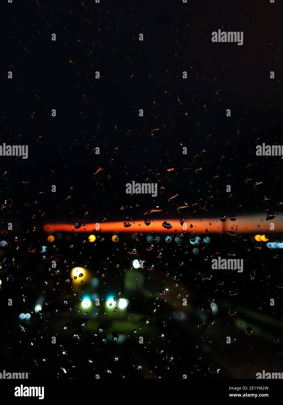Gocce di pioggia su vetro. Livin durante il tramonto. Cielo notturno con una striscia arancione brillante. Foto Stock