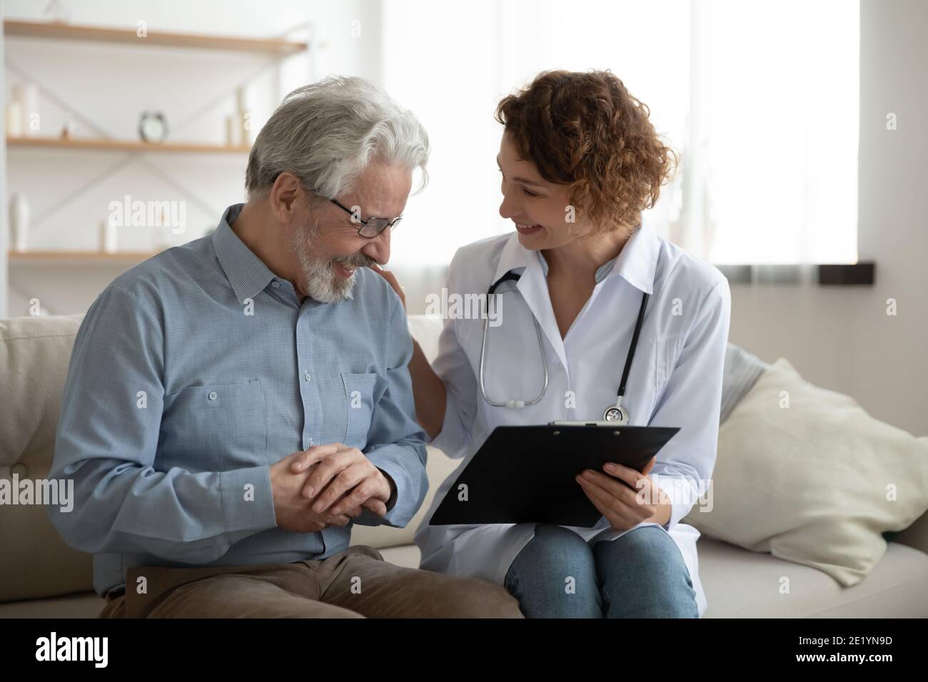 Buon medico che condivide buone notizie sui risultati dei test con il paziente anziano. Foto Stock