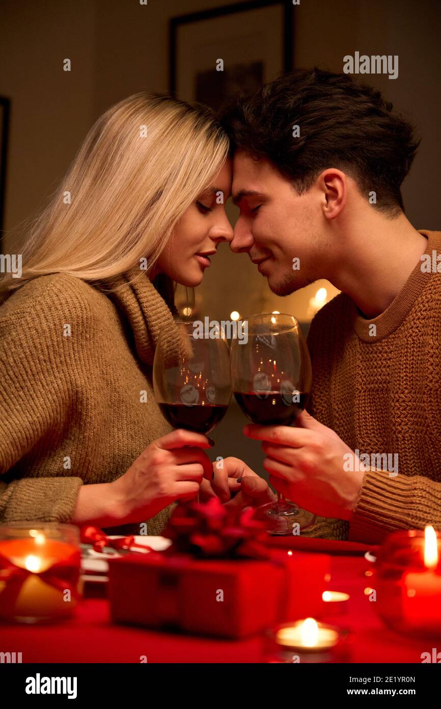 Felice giovane coppia in amore bonding, tenendo bicchieri, bere vino. Foto Stock