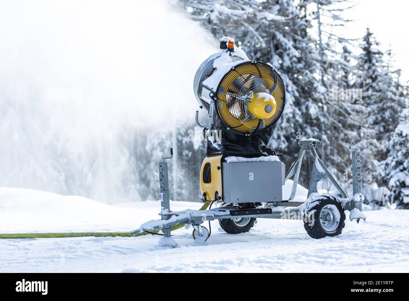 Cannone da neve o macchina spruzzano acqua e neve su una pista da sci o di fondo. Foto Stock
