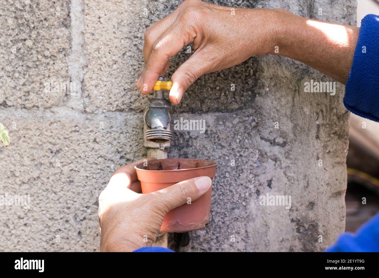 mani di donna che aprono il rubinetto d'acqua nel giardino Foto Stock