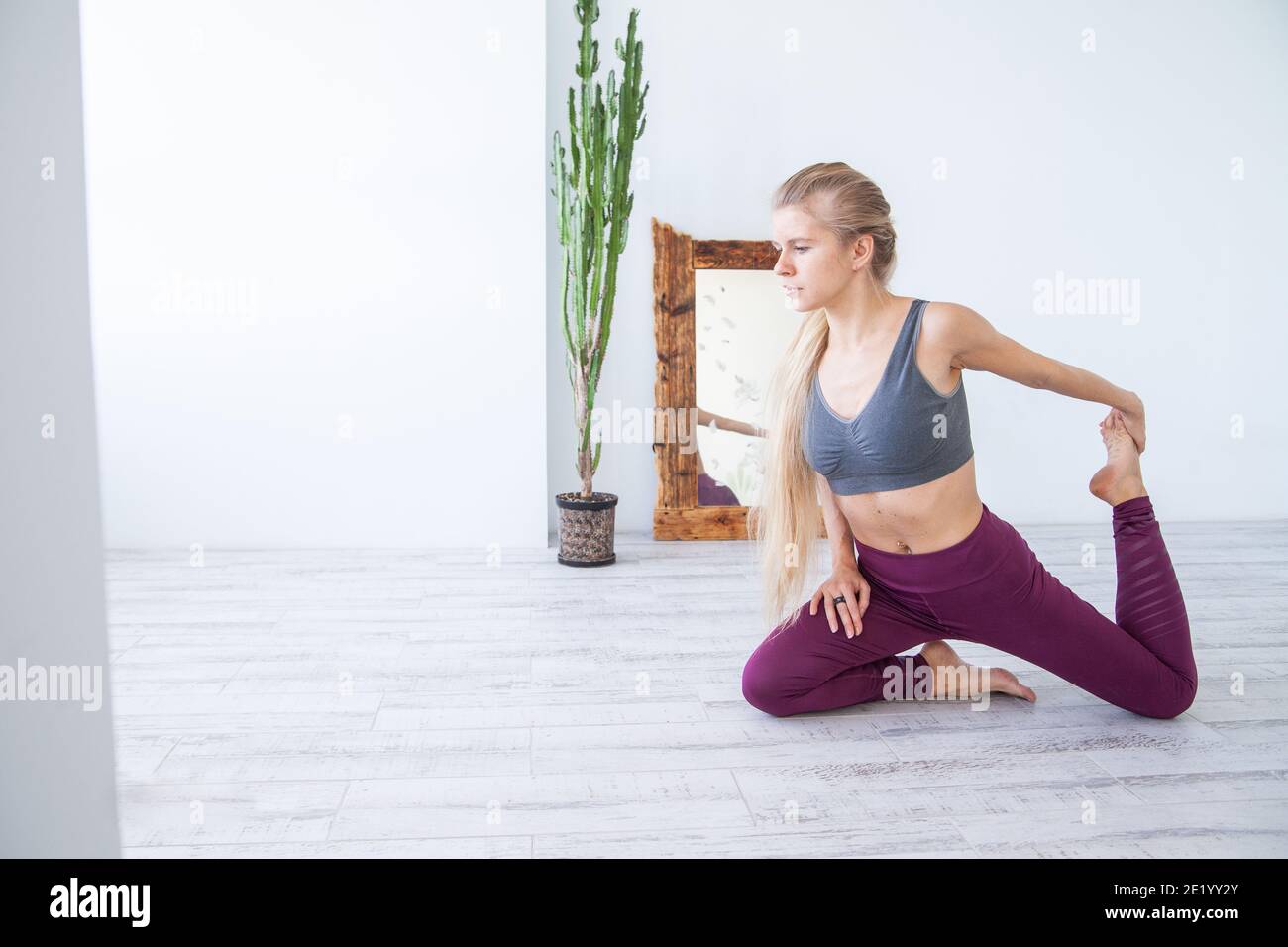 Fit atleta che si allunga sul pavimento a casa Foto Stock