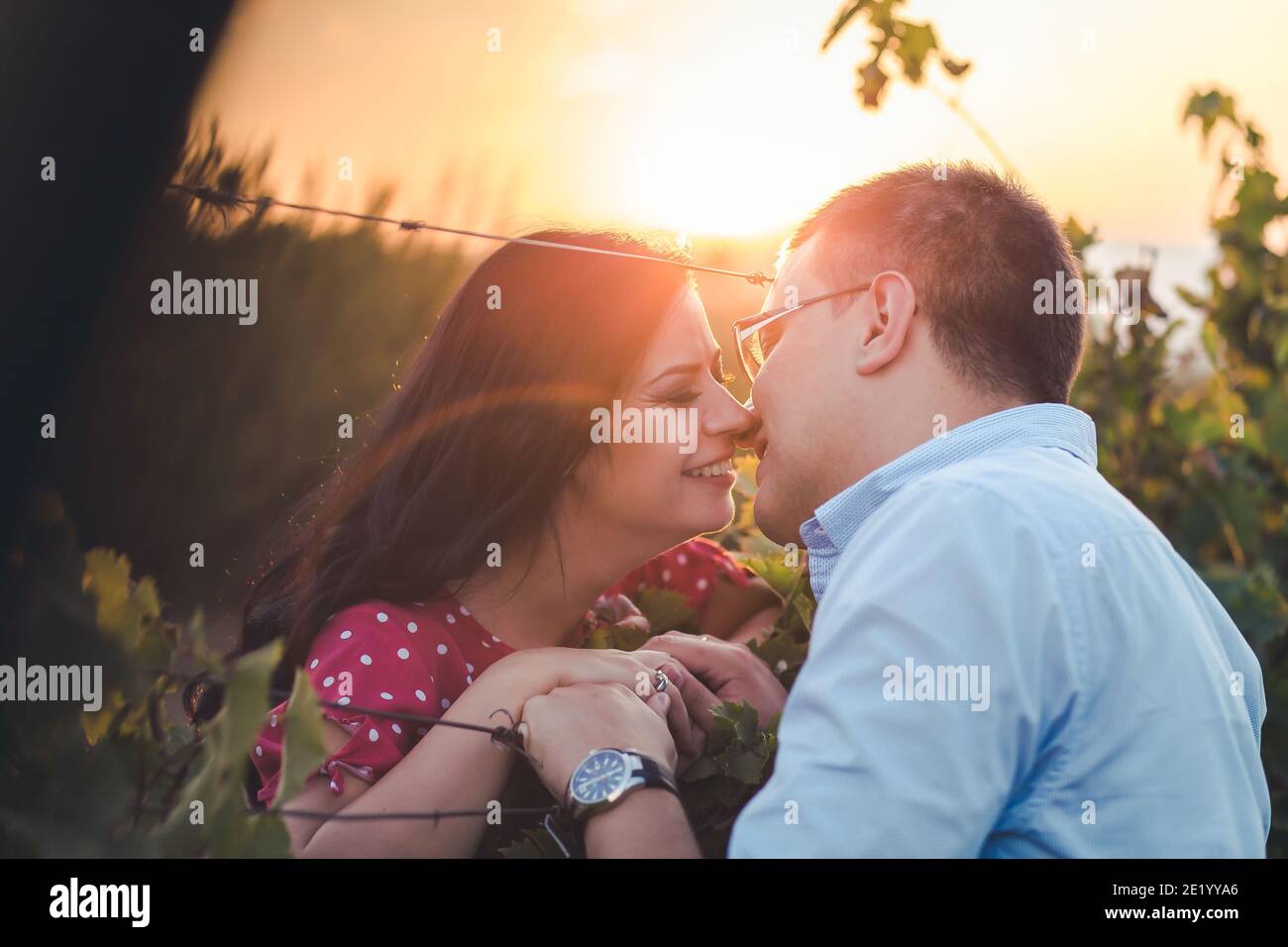 Ritratto esterno di una giovane coppia baciante. Romanticismo, gesti romantici. Luce pomeridiana Foto Stock
