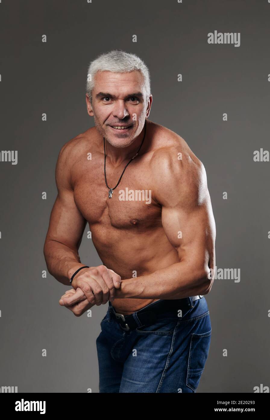 Bodybuilder mostra il suo musculo in studio su sfondo nero Foto Stock