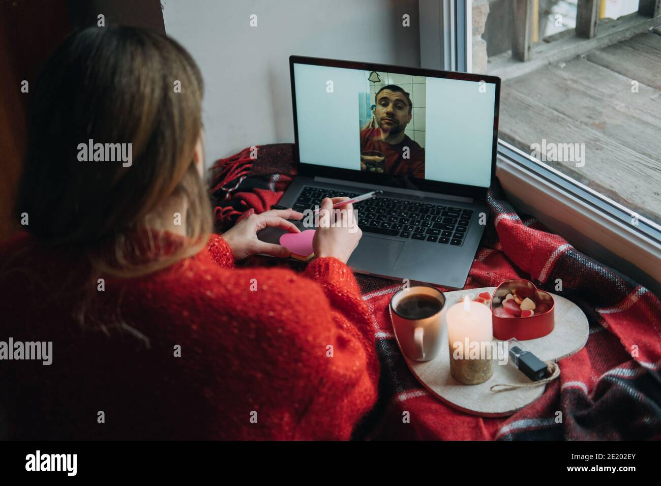 Donna che usa l'app online dating sul laptop. Giorno di San Valentino durante l'epidemia di Coronavirus. Amore a distanza, solitudine in auto-isolamento nel tempo di Foto Stock