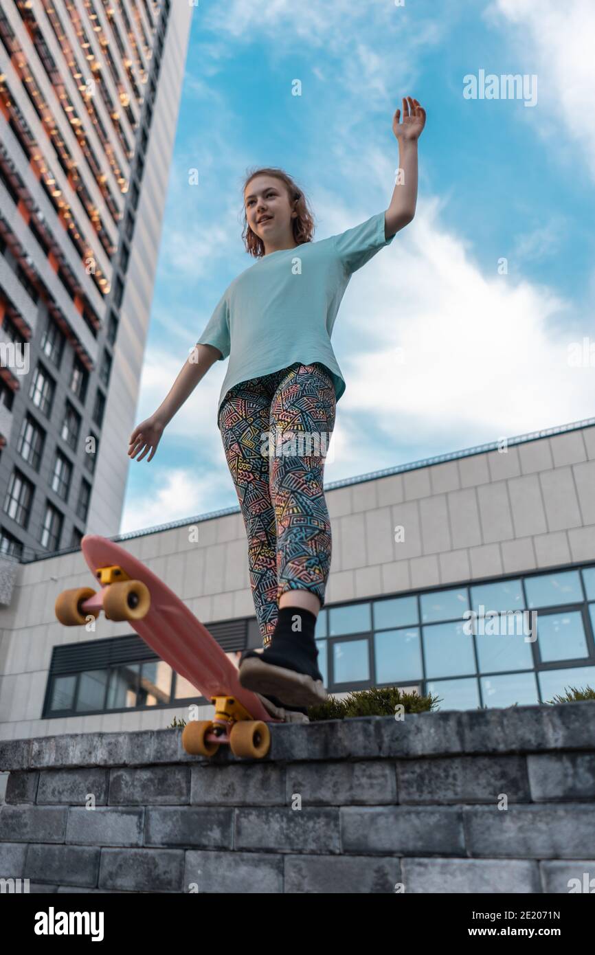 bella ragazza giovane in piedi con bordo penny su strada a. giorno di sole Foto Stock