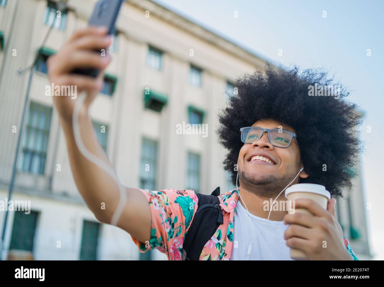 Uomo latino che prende un selfie con il telefono all'aperto. Foto Stock