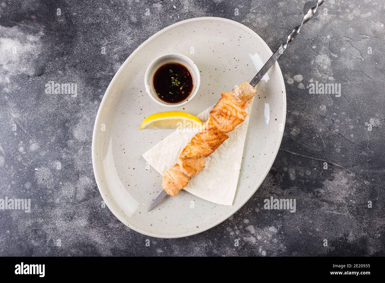 Spiedini di salmone grigliati serviti con limone e salsa. Vista dall'alto Foto Stock