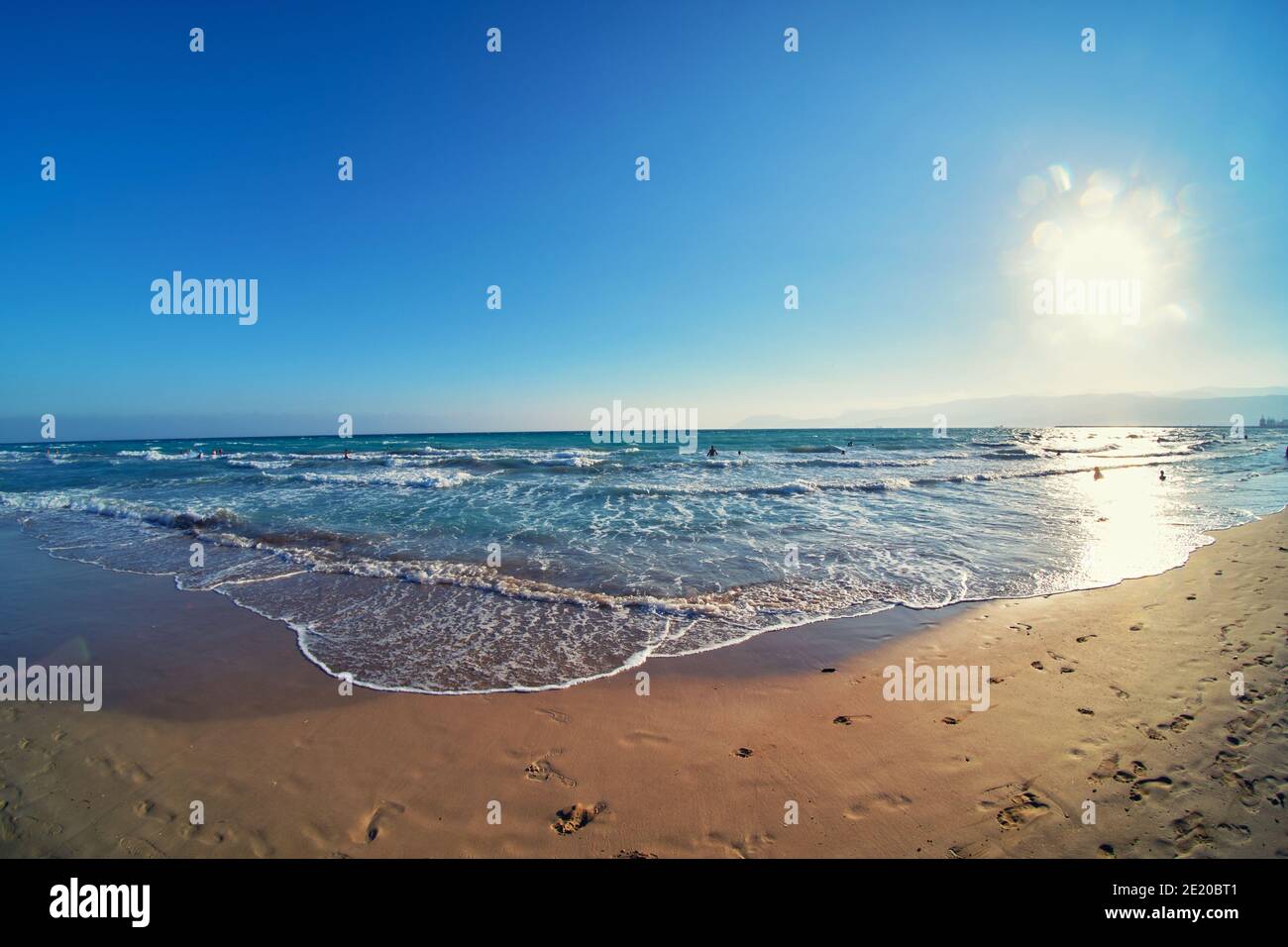 Surf serale e tramonto sulla spiaggia di sabbia Foto Stock