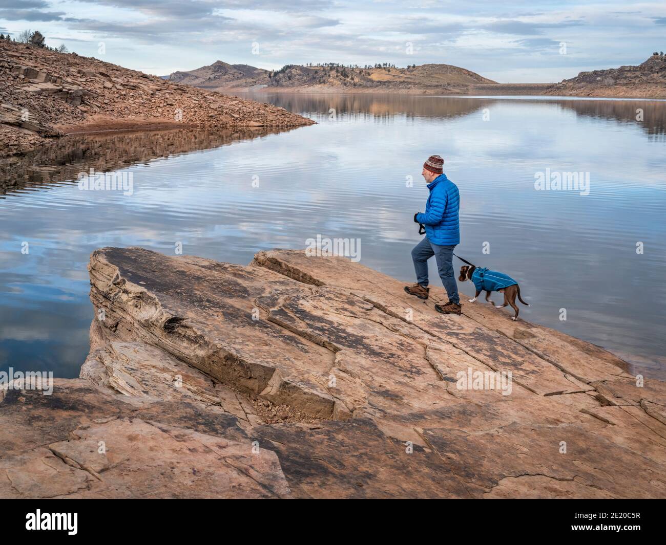 L'escursionista maschile senior sta camminando con il cane pitbull su una riva di lago di montagna ai piedi delle Montagne Rocciose, Horsetooth Reservoir - una famosa ricreazione Foto Stock