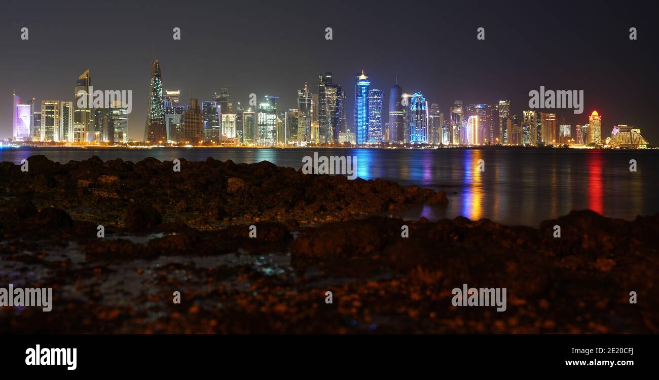 Lo skyline della città di Doha, la capitale del Qatar, visto di notte dalla strada della Corniche Foto Stock