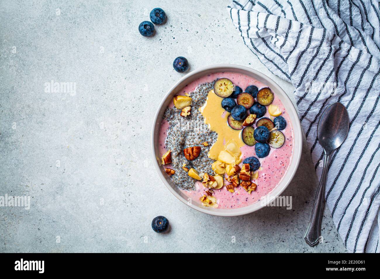 Ciotola Acai con semi di chia, bacche, noci e burro di arachidi. Concetto di colazione salutare. Foto Stock