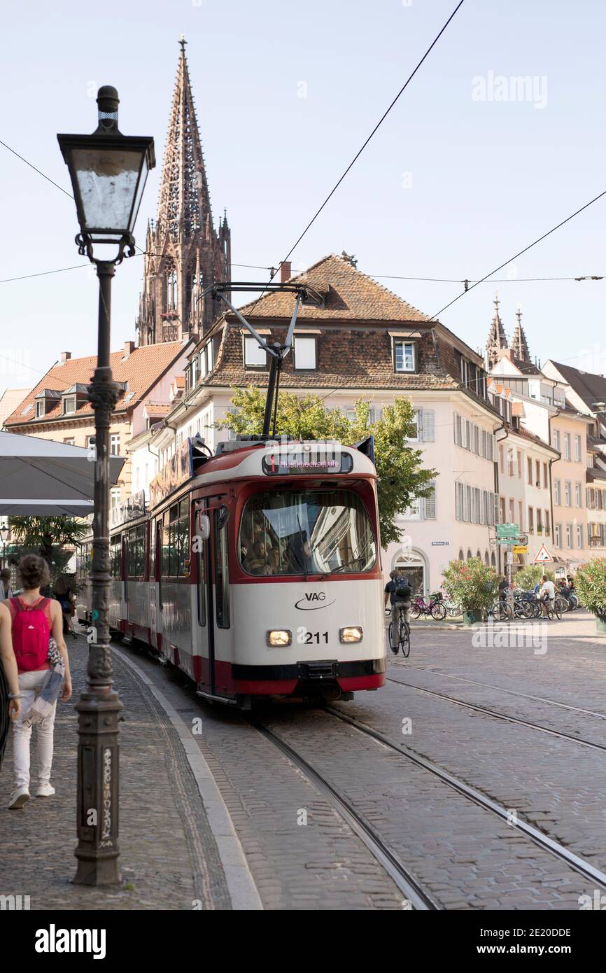 Un tram numero 1 in stile vintage verso Musikhochschule su Oberlinden a Friburgo in Breisgau, Germania, con la guglia della cattedrale. Foto Stock