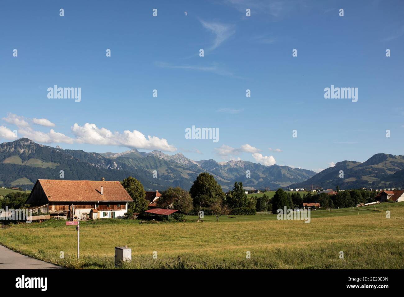 Le Alpi svizzere oltre la città di Riaz nel distretto di Gruyère nel cantone di Friburgo in Svizzera. Foto Stock