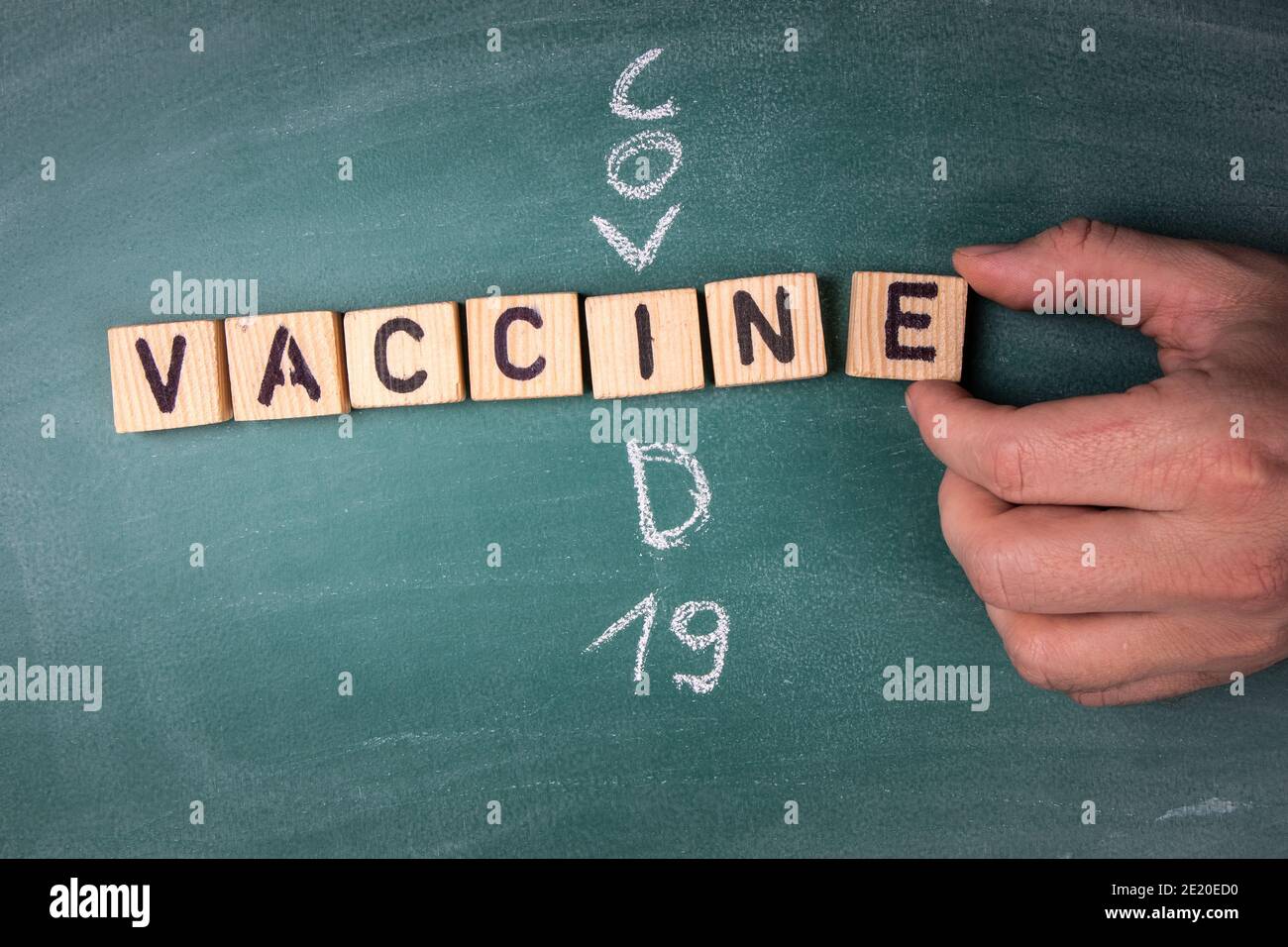 Vaccino. Testo delle lettere dell'alfabeto ligneo e scritto sulla lavagna Covid-19. Foto Stock