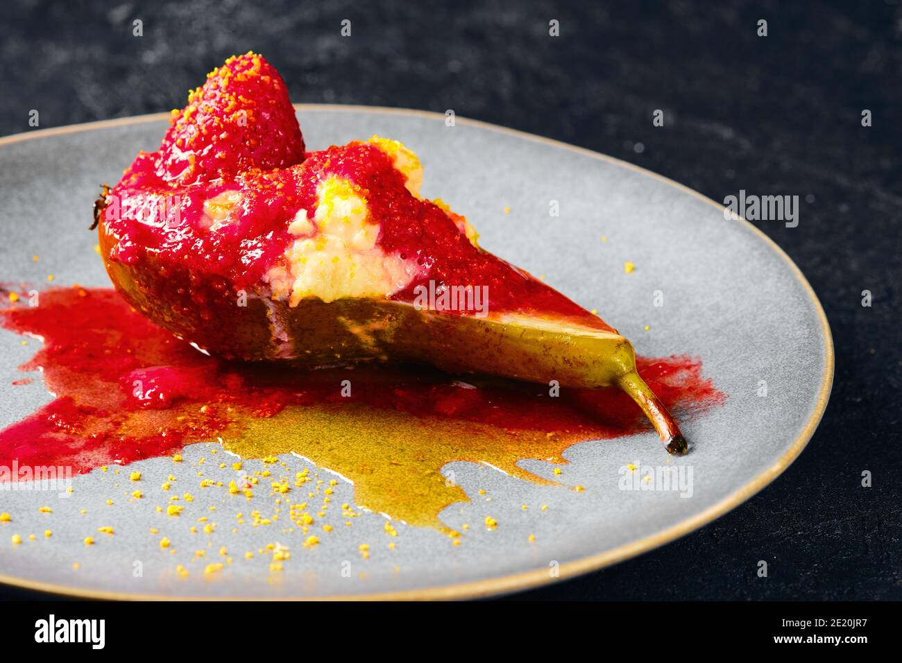 Vista ravvicinata delle pere dolci al forno con mascarpone, sciroppo di caramello e marmellata di fragole Foto Stock