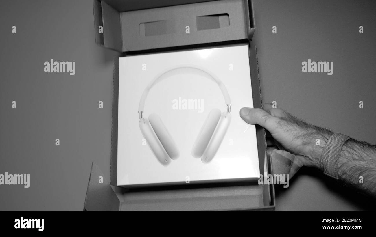 Parigi, Francia - 7 gennaio 2020: Pacchetto di tenuta per mano maschile POV dei migliori auricolari Apple Computers AirPods Max con Adaptive EQ, cancellazione attiva del rumore, modalità di trasparenza h1 chip e Siri Foto Stock