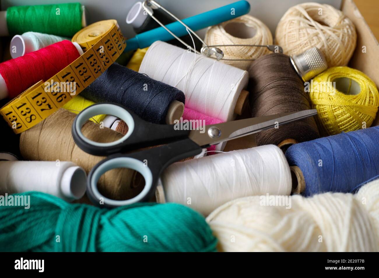 Strumenti di base per cucire, tra cui filo, forbici, spille e metro a nastro Foto Stock