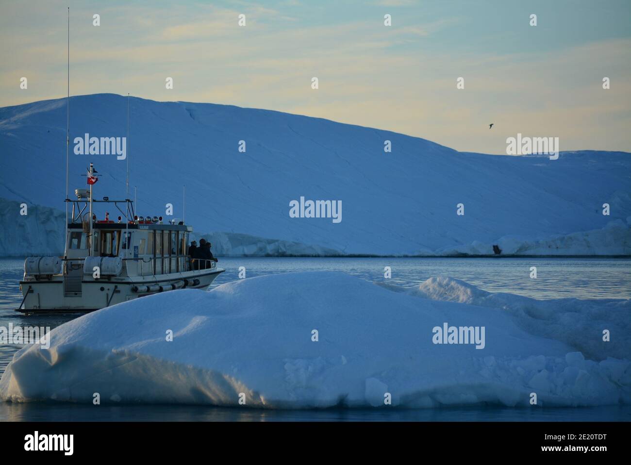 Gita in barca tra enormi iceberg nella baia di Disko, Ilulissat icefjord al sole di mezzanotte a luglio, patrimonio mondiale dell'UNESCO influenzato dal cambiamento climatico Foto Stock