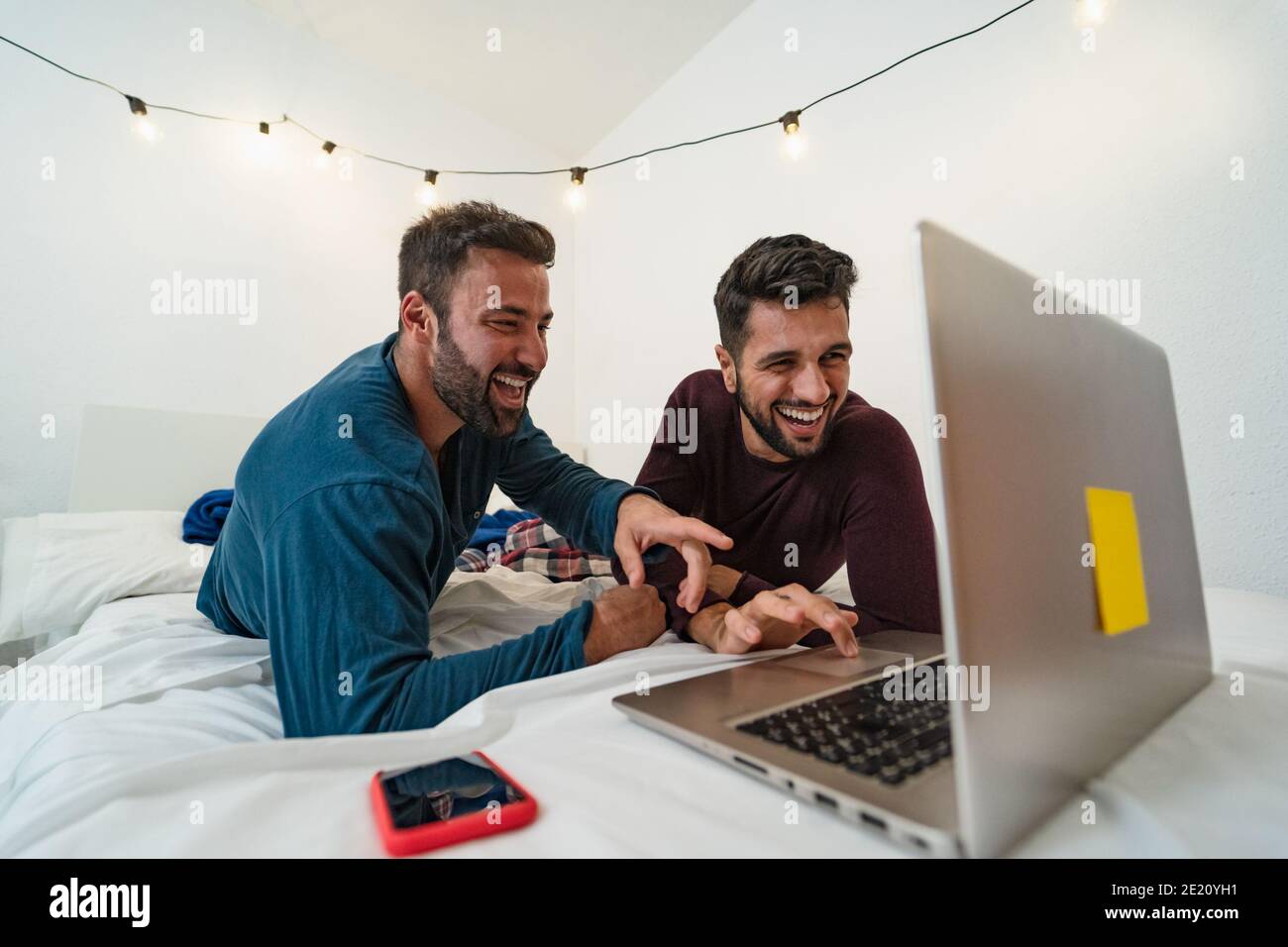 Felice coppia di uomini gay che usano il computer portatile a letto - omosessuale amore e uguaglianza di genere nel concetto di relazione Foto Stock