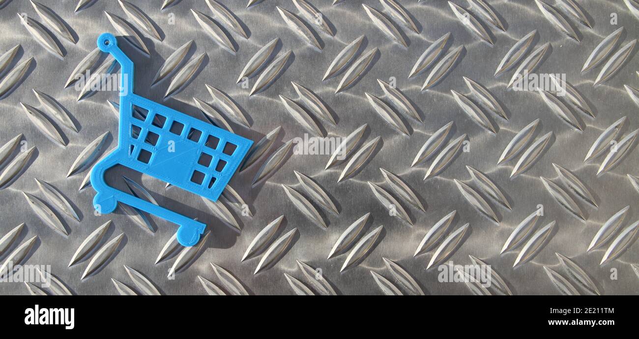 un piccolo carrello blu su una piastra a scacchiera Foto Stock