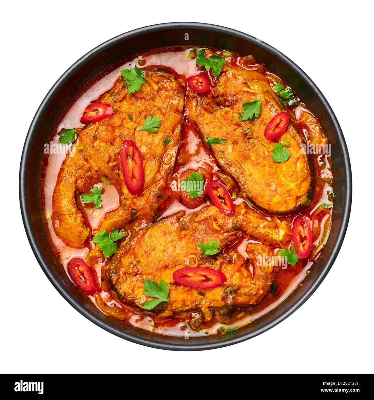 Macher Jhol in ciotola nera isolata su bianco. Cucina indiana Bengalese Pesce curry. Cibo e pasti asiatici. Vista dall'alto Foto Stock