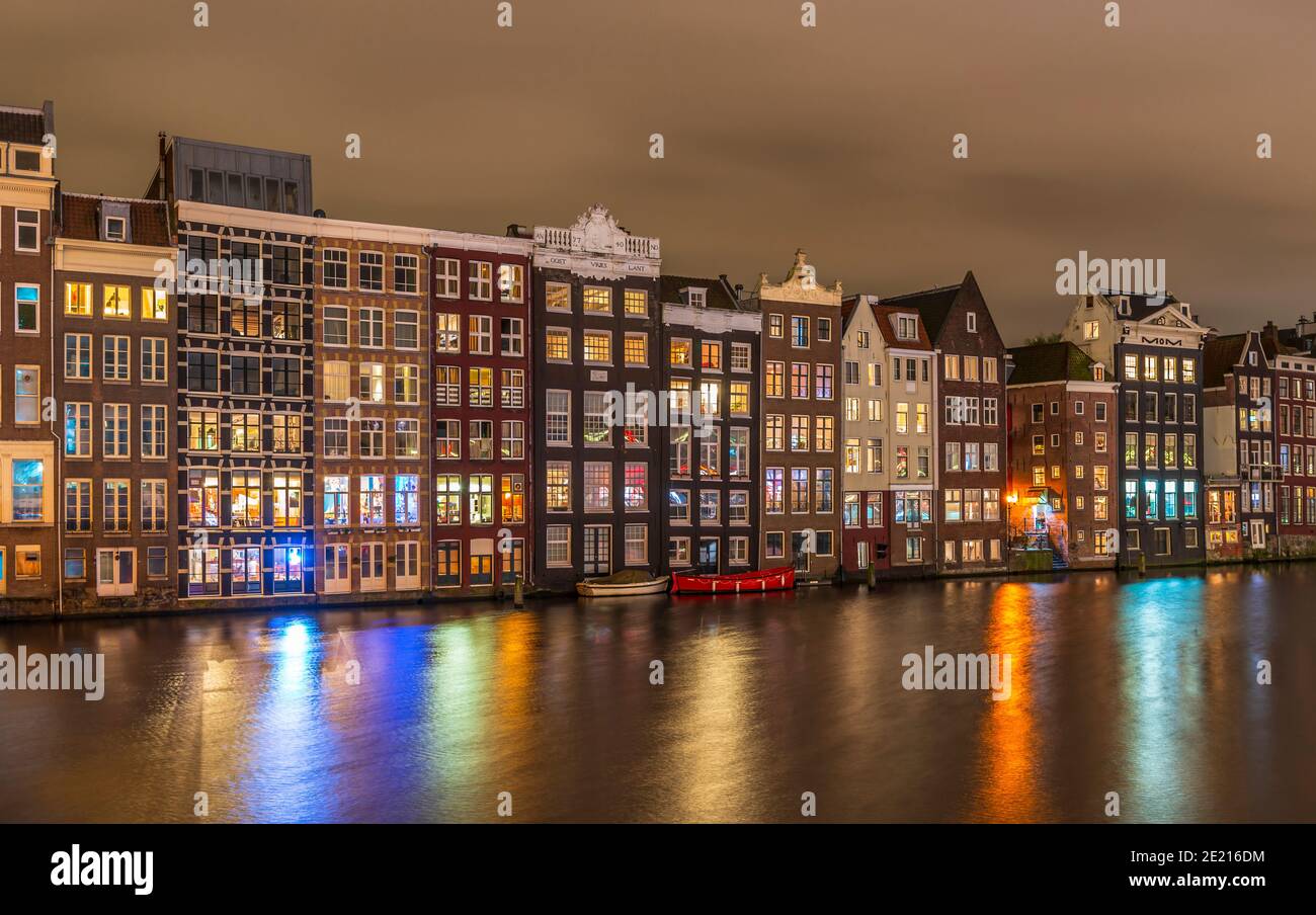 Case tipiche sul Damrak di notte, ad Amsterdam, Paesi Bassi Foto Stock