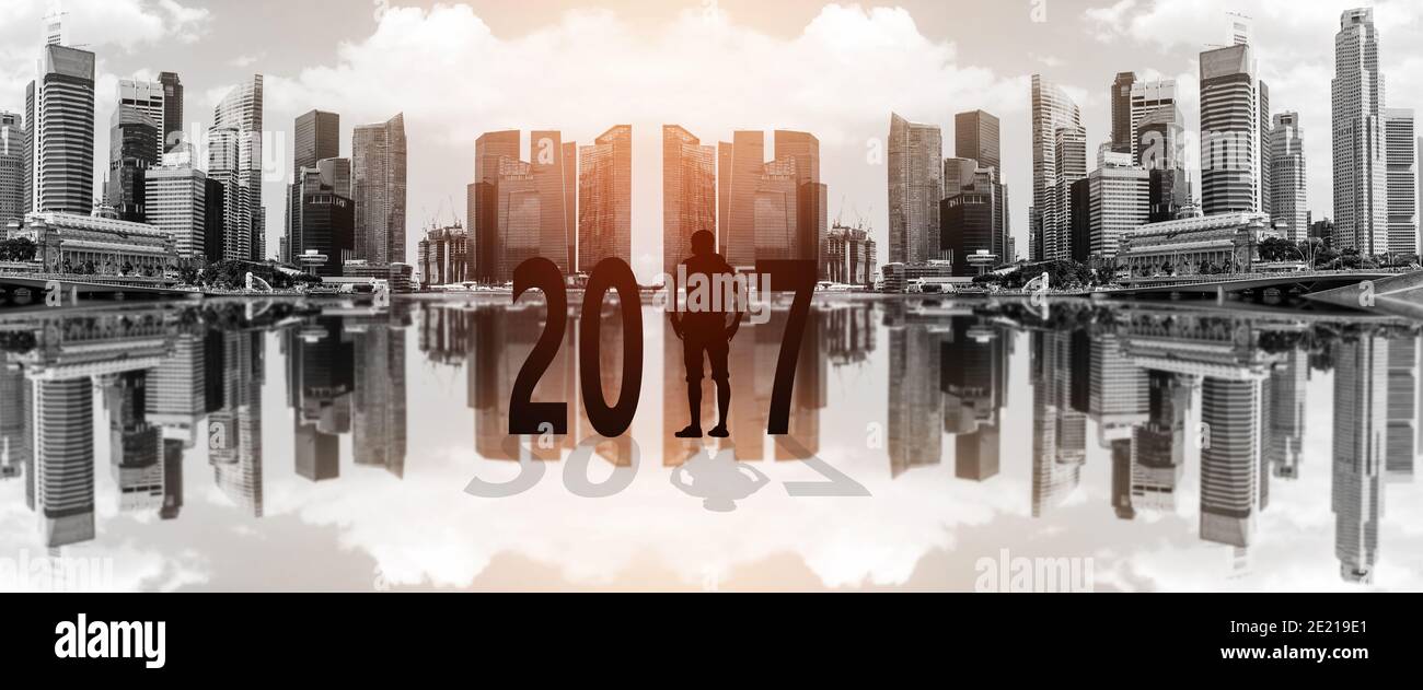 Silhouette di giovane uomo in piedi tra 2017 anni con bella città sfocata sfondo. Foto Stock