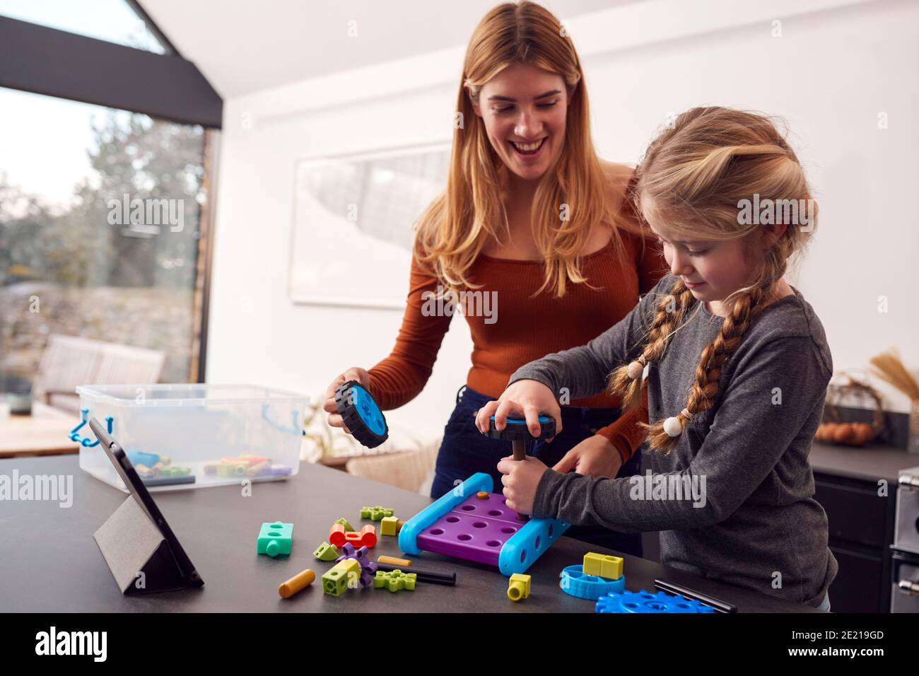 Madre con figlia che gioca con Engineering Construction Kit insieme a. Casa Foto Stock
