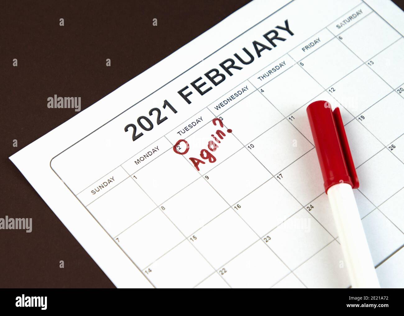 Concetto di giorno di Groundhog. La parola Againe è scritta sul calendario il 02 febbraio. Sfondo marrone. Disposizione piatta. Foto Stock