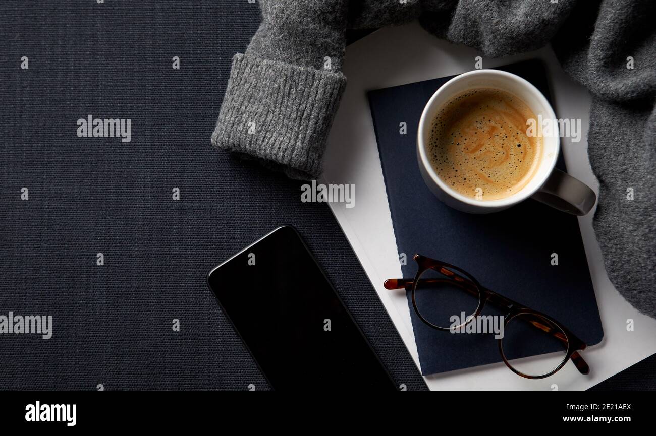 Flat Lay Lifestyle Shot con jumper notebook e telefono cellulare Su sfondo nero Foto Stock