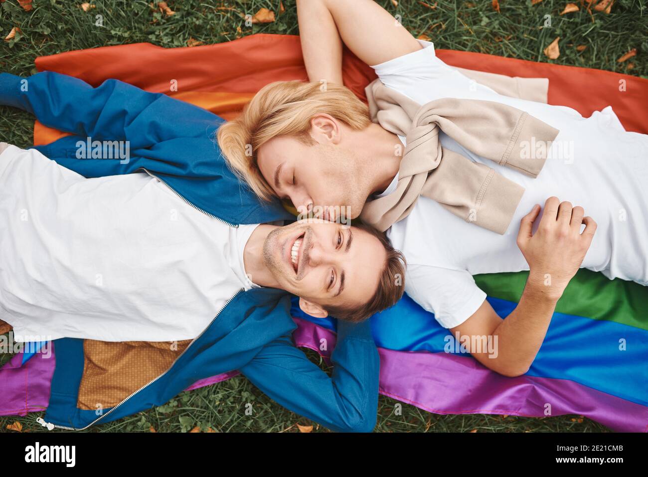 Coppia gay amorevole che ha date romantiche all'aperto. Due bei uomini che  giacciono insieme sulla bandiera dell'orgoglio di LGBT Foto stock - Alamy