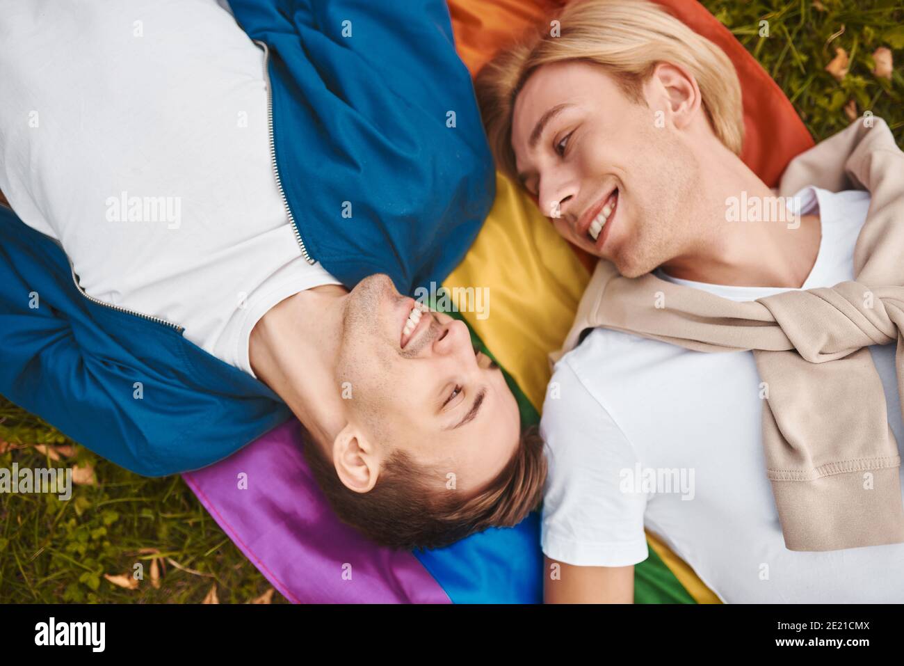 Coppia gay amorevole che ha date romantiche all'aperto. Due bei uomini che  giacciono insieme sulla bandiera dell'orgoglio di LGBT Foto stock - Alamy