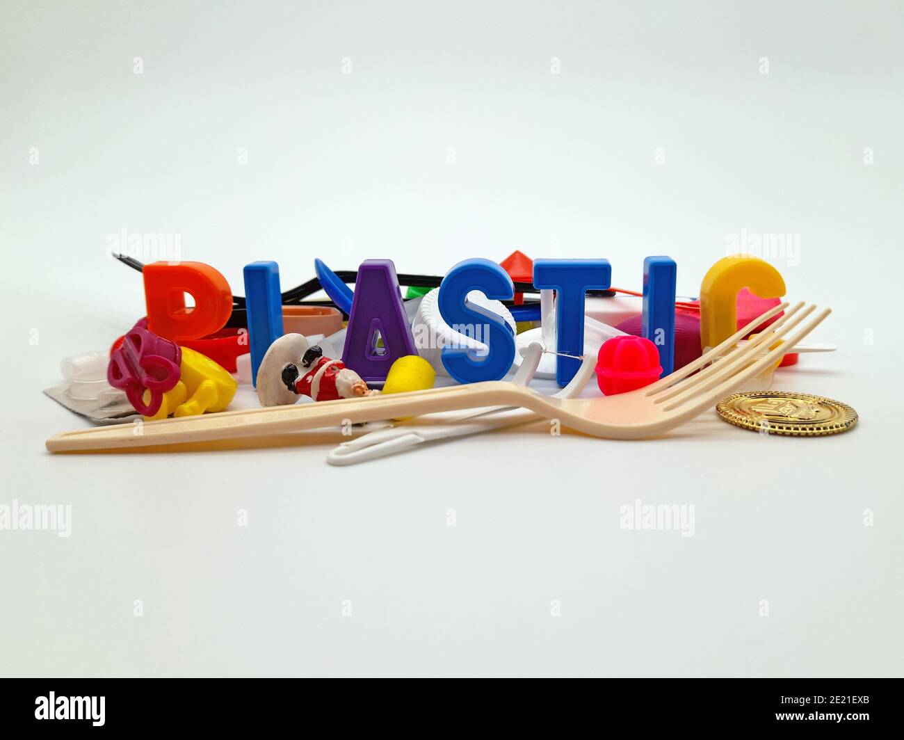 Stoccolma, Svezia - 10 gennaio 2021: La parola 'plastica' è scritta con lettere di plastica circondate da diversi oggetti di uso quotidiano in plastica. Foto Stock