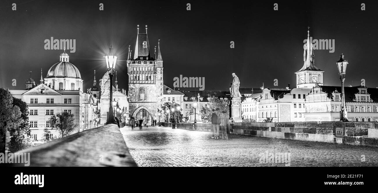 Passeggiata sul Ponte Carlo, ceco: Karluv Most, di notte. Statue illuminate e Torre del Ponte della Citta' Vecchia. Praga, Repubblica Ceca. Immagine in bianco e nero. Foto Stock