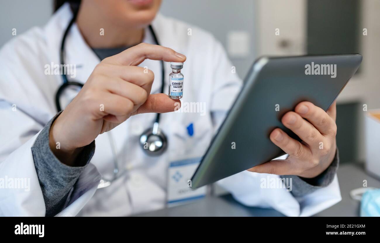 Medico femminile che fa consultazione online mostrando vaccino covid-19 Foto Stock